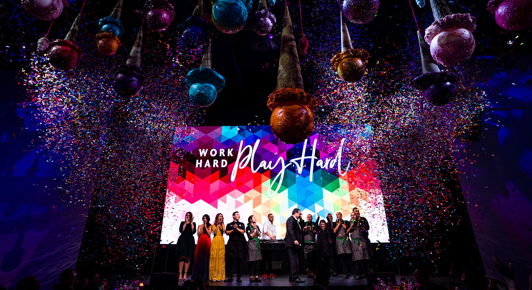 Corporate event celebration with confetti and staff members clapping