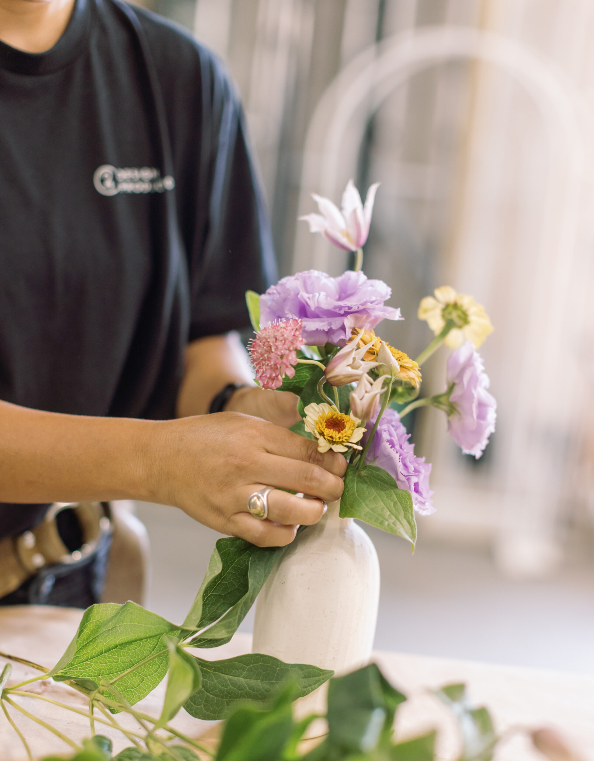 Team member arranging flowers in a small vase.